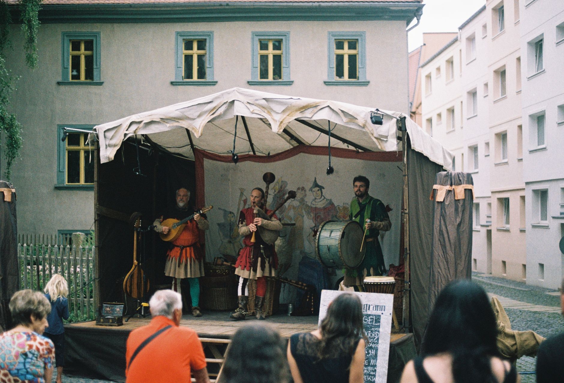 Street musicians performing traditional music on a small stage in Görlitz, Germany.