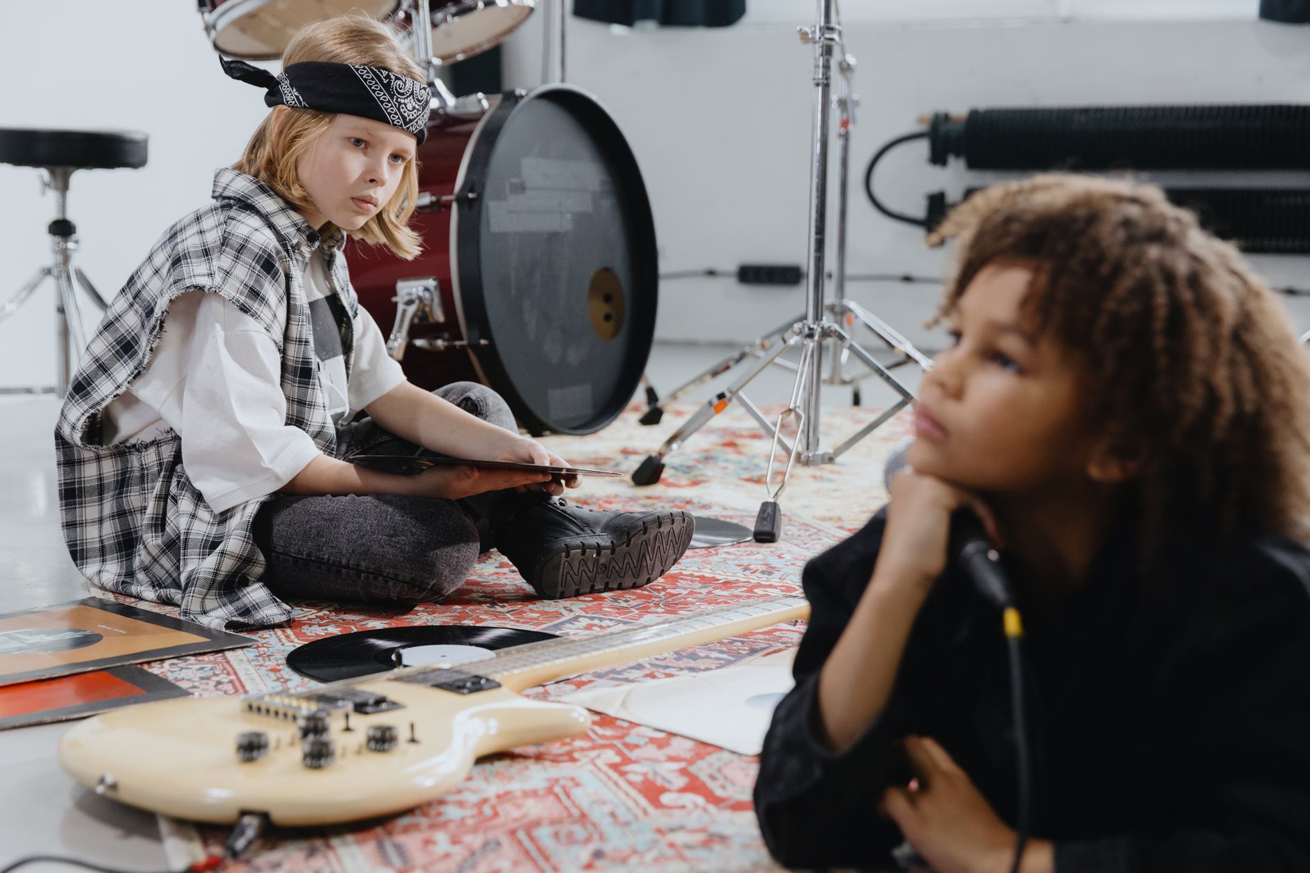 Two kids exploring musical instruments during a creative indoor session.