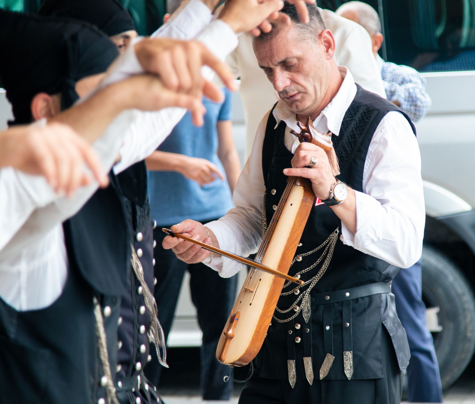 A Turkish musician playing a Pontian lyre outdoors during a street performance.