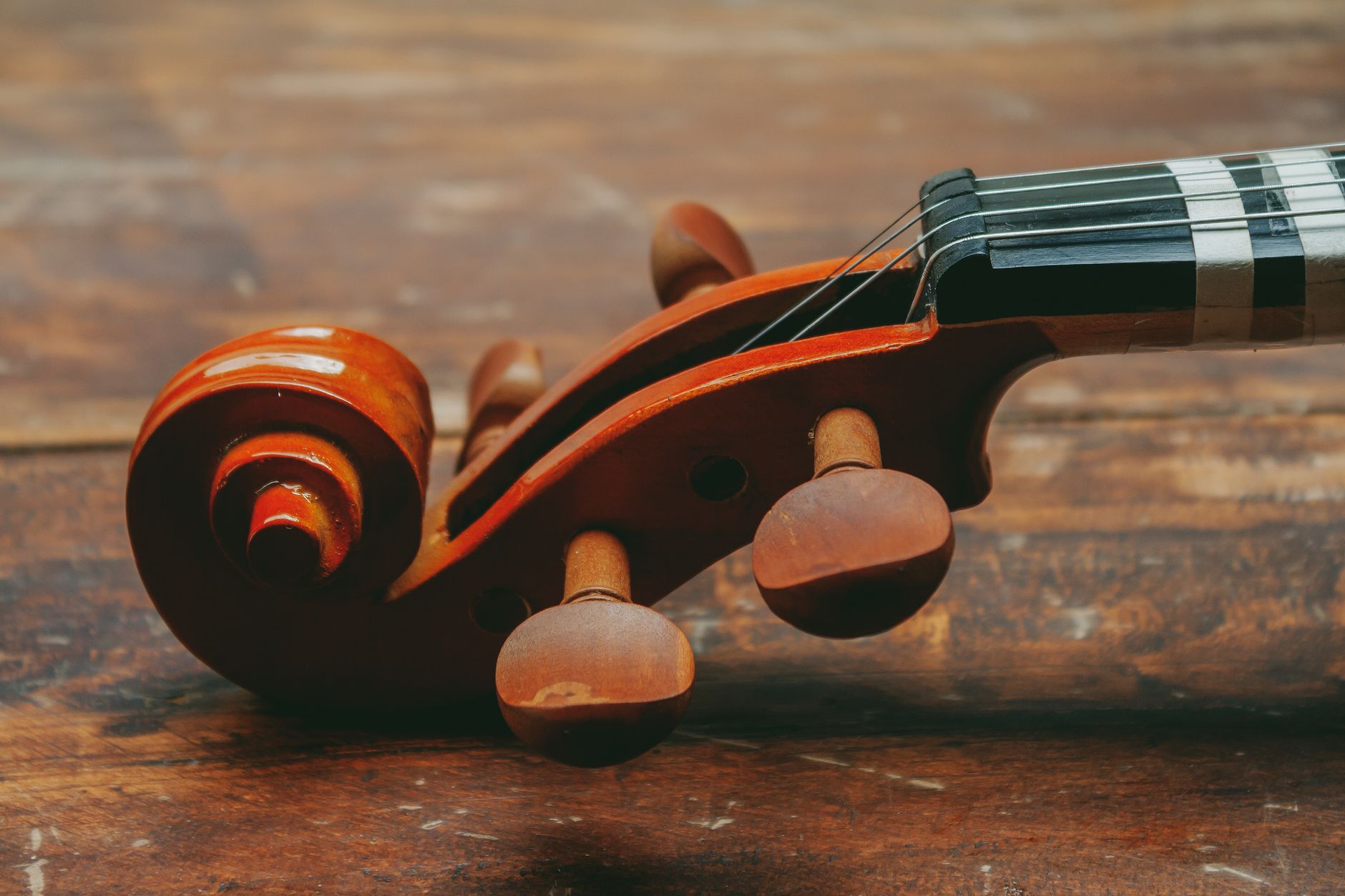 Detailed close-up of a violin scroll on a wooden surface in Mérida, Venezuela.