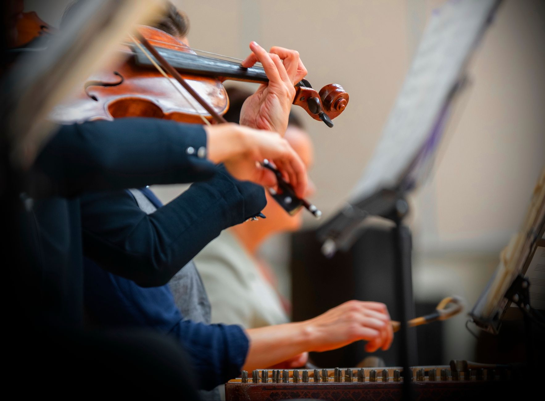 Detailed view of violinists in a live performance, showcasing orchestral musicianship.