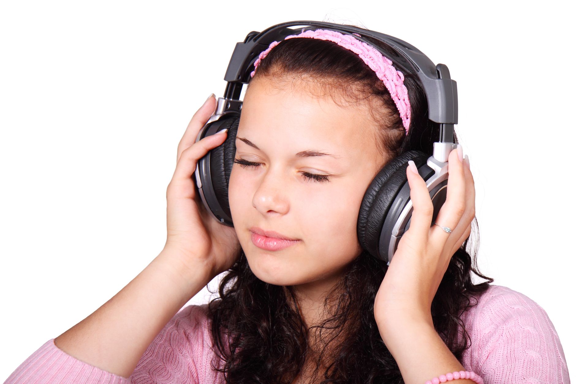 A serene young woman with headphones on, lost in music, isolated on white.