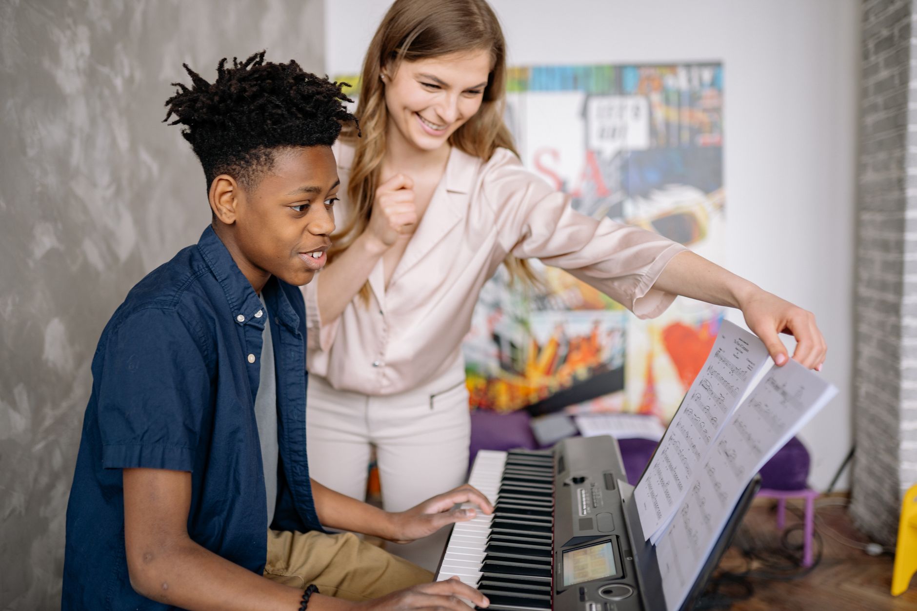 A young boy receives piano lessons from a dedicated teacher at home, fostering musical skills.