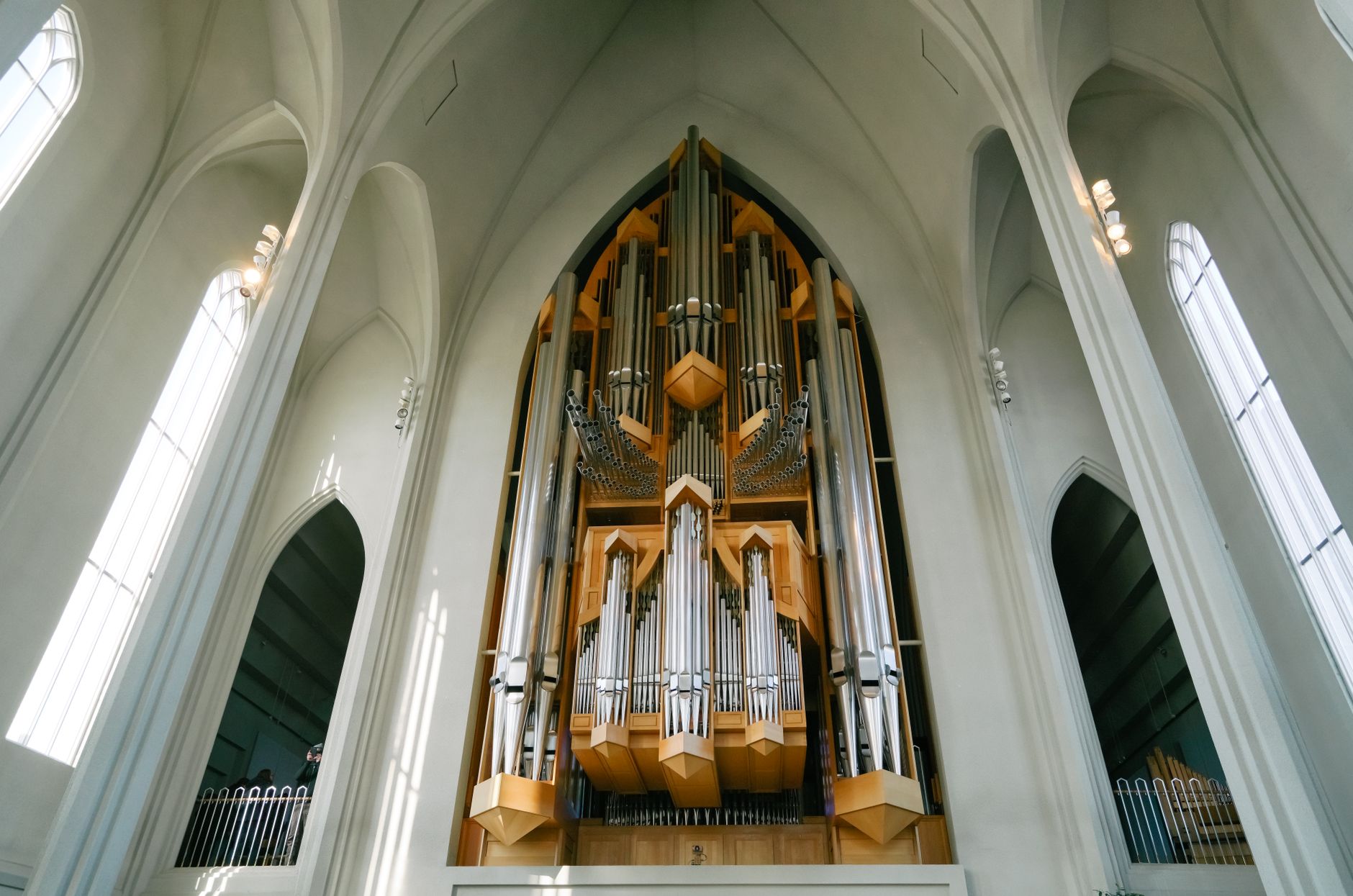 A stunning view of a large pipe organ inside a gothic cathedral, showcasing intricate design and religious architecture.