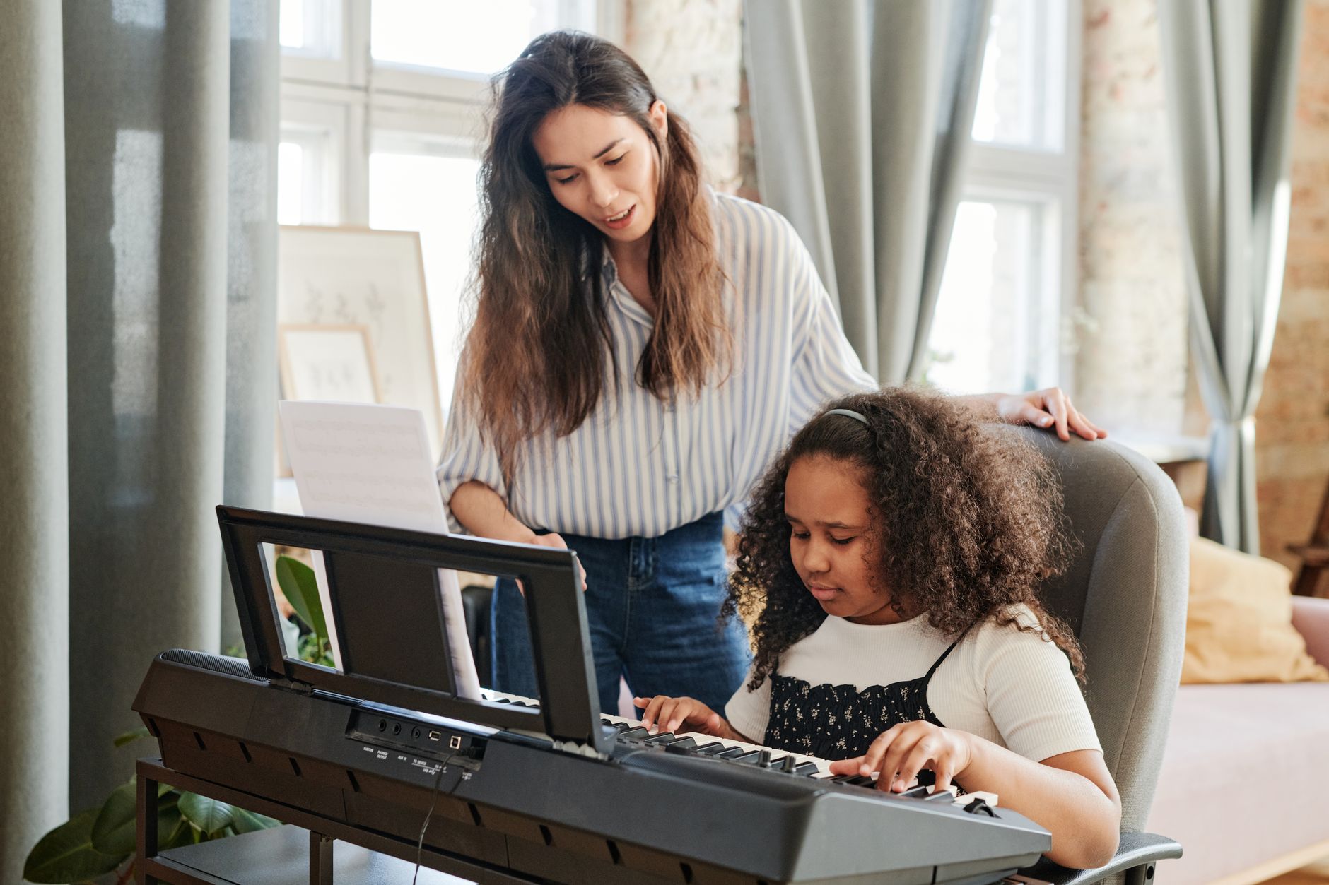 A student having piano lessons with a teacher in a cozy room setting.
